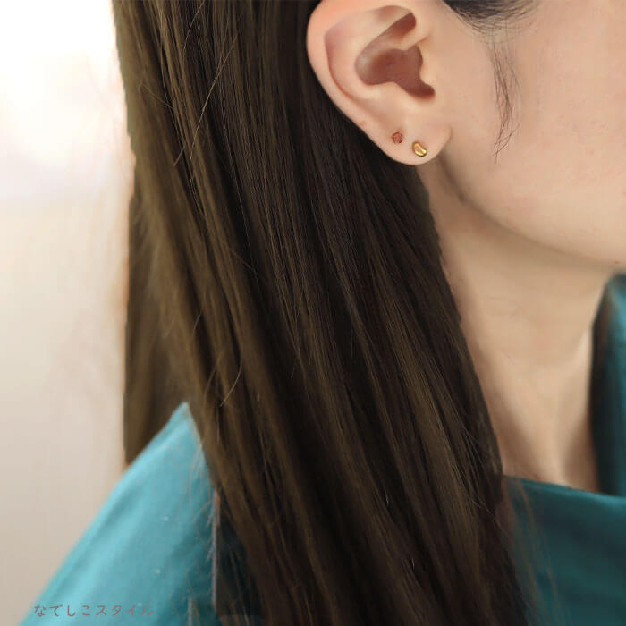 おまめゴールドカラーとブランデートパーズ３ミリのピアスを複数のピアスホールに着けている３０代女性
