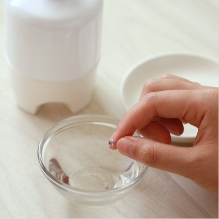 ボウルにピアスを浸そうとしている画像