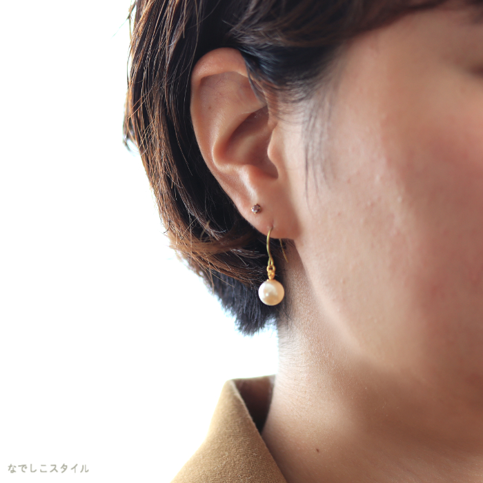 パールのピアスをつけた女性の耳元画像