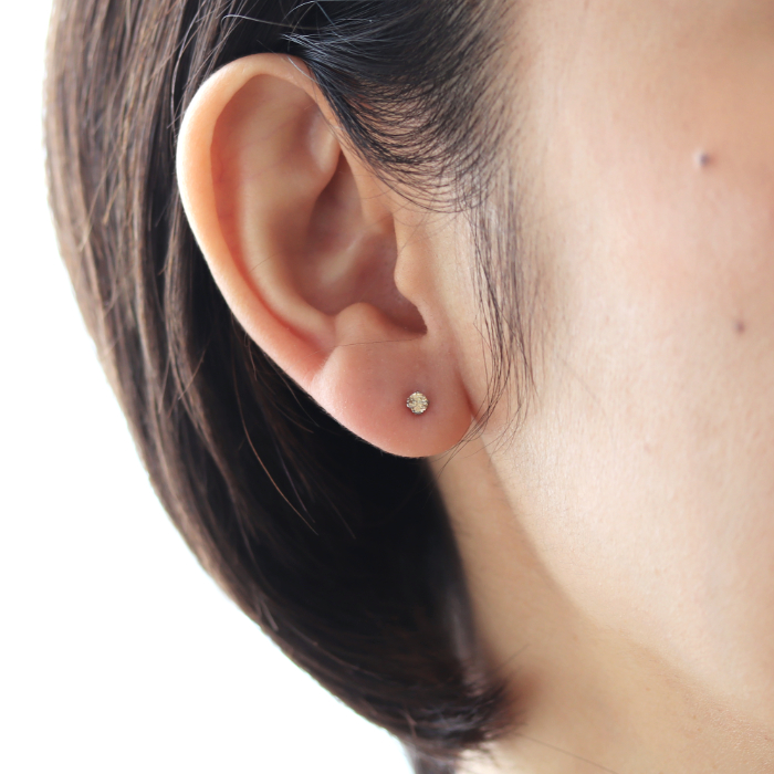 シャンパンダイヤのピアスを着けた女性の耳元画像