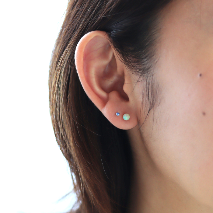 黄色の京都オパールのピアスと小粒のアクアマリンのピアスを着けた女性の耳元画像