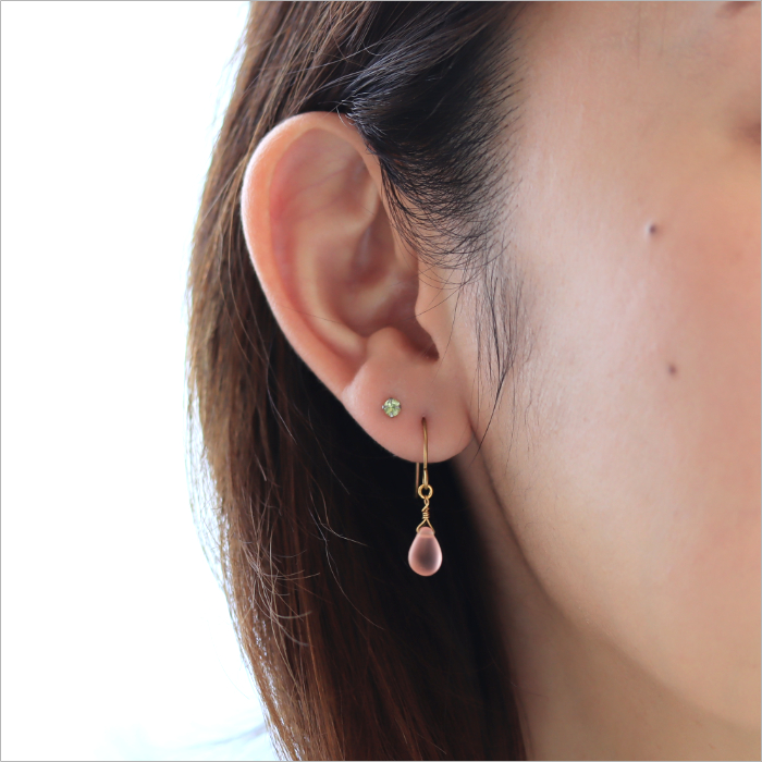 黄色の京都オパールのピアスと小粒のアクアマリンのピアスを着けた女性の耳元画像