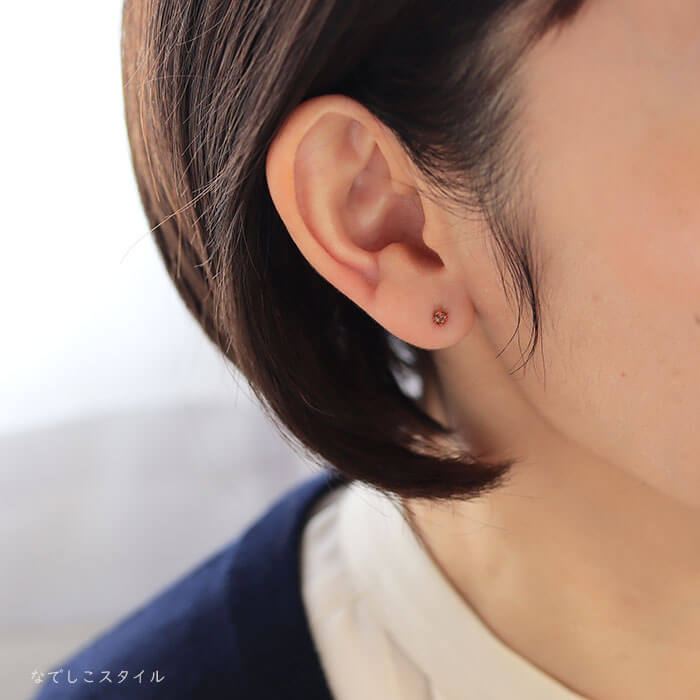 仕事用のカーディガンを着た４０代女性がブランデートパーズを耳に着けた写真