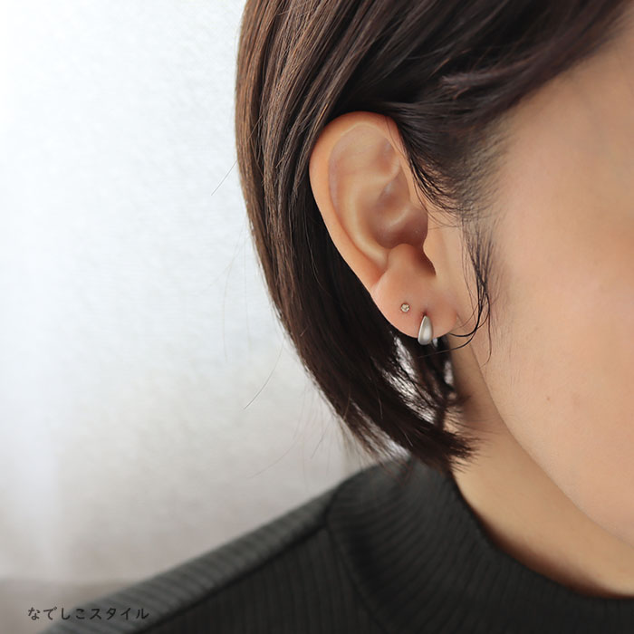 おぼろ月プラチナカラーとシャンパンダイア２ミリのピアスを複数のピアスホールに着けている４０代女性