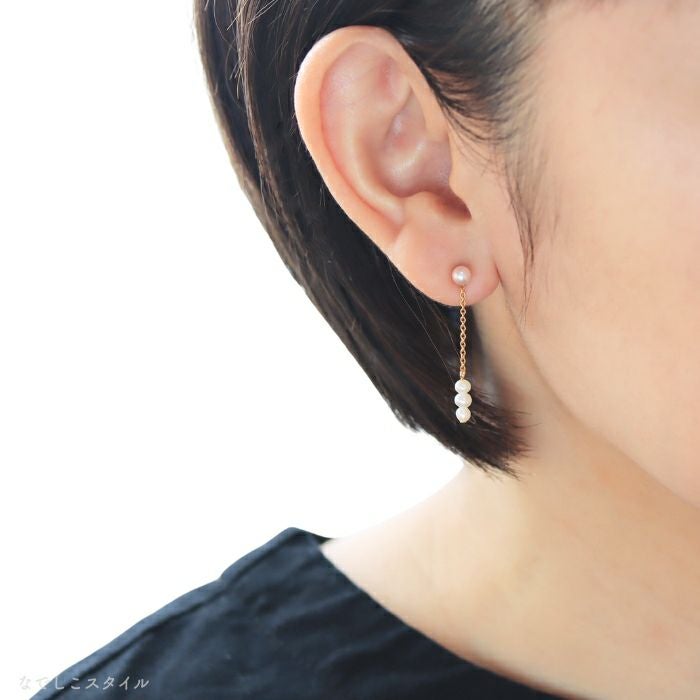 桜色グラスパールとチャームを耳に着けた４０代女性の画像