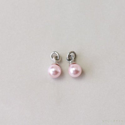 プラチナカラーの金具を使った桜色パールチャームを置いた画像