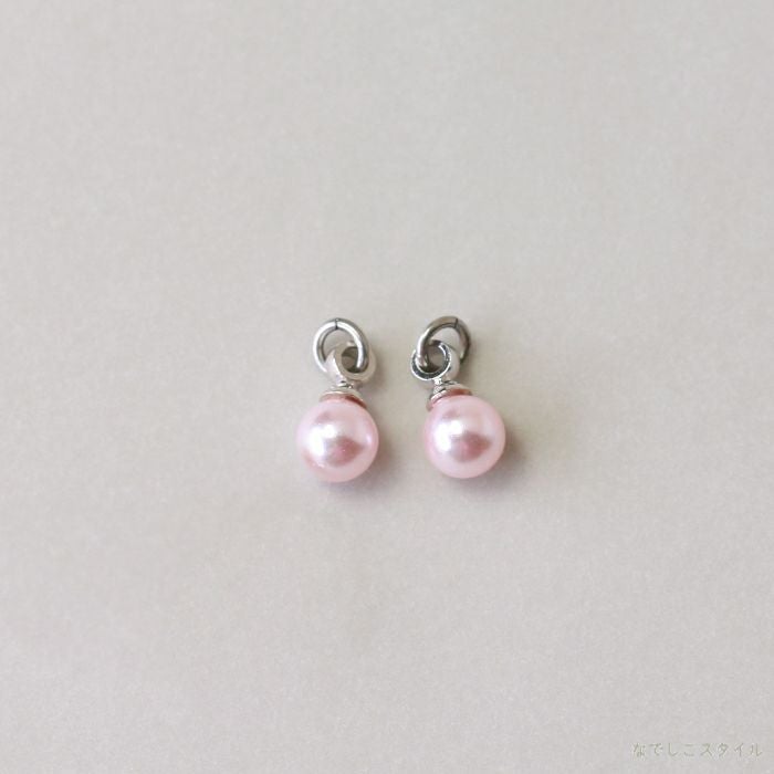 プラチナカラーの金具を使った桜色パールチャームを置いた画像