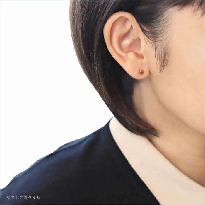 ゴールドカラーブランデートパーズ４ｍｍを着けた40代女性が冬服を着ているイメージ画像