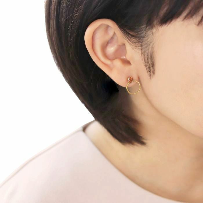 ゴールドカラーブランデートパーズ４ｍｍとリングチャームをあわせたピアスを着けた40代女性のイメージ画像