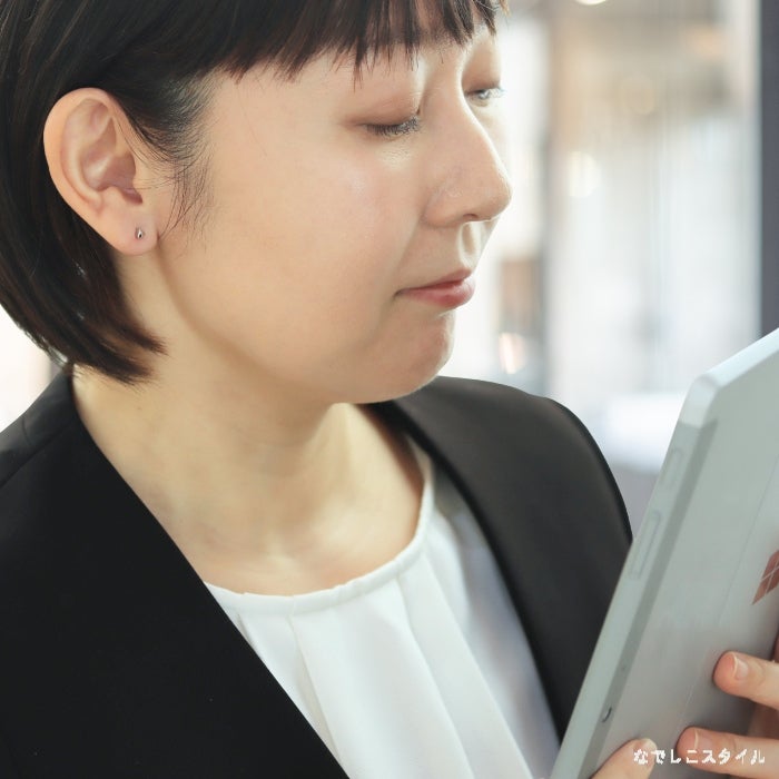 金属アレルギー対応のチタンピアス「カケラ(プラチナカラー)」を耳に着けてお仕事をしている40代女性