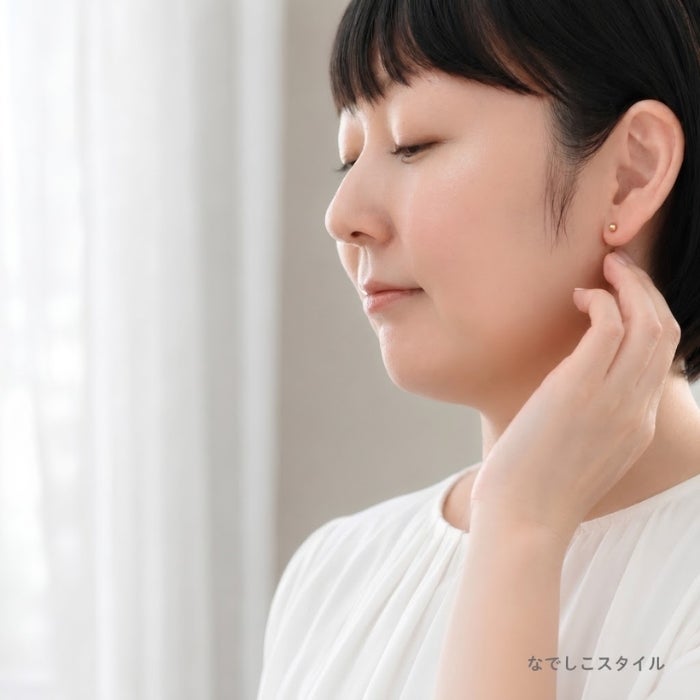 金属部分すべてがチタン純度99.5％の丸玉ピアスゴールドカラーを耳に着けた女性の普段つけているイメージ画像